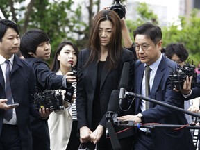 Former Korean Air Senior Vice President Cho Hyun-min, center, arrives at a police station in Seoul, South Korea, Tuesday, May 1, 2018. The Korean Air heiress has apologized in her first public appearance as a suspect in an abuse of power case as public calls urging her family to resign grow.