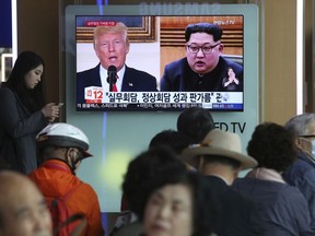 People watch a TV screen showing images of U.S. President Donald Trump, left, and North Korean leader Kim Jong Un during a news program at the Seoul Railway Station in Seoul, South Korea, Tuesday, May 29, 2018. A team of American diplomats involved in preparatory discussions with North Korea ahead of a potential summit between Trump and Kim left a hotel in Seoul on Tuesday amid speculation that they are resuming the talks. The signs read: "Working-level talks."