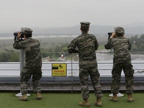 South Korean marine force members look toward North's side through binoculars at the Imjingak Pavilion in Paju near the border village of Panmunjom, South Korea, Wednesday, May 16, 2018. North Korea on Wednesday canceled a high-level meeting with South Korea and threatened to scrap a historic summit next month between U.S. President Donald Trump and North Korean leader Kim Jong Un over military exercises between Seoul and Washington that Pyongyang has long claimed are invasion rehearsals.