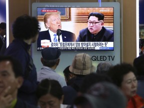 People watch a TV screen showing file footage of U.S. President Donald Trump, left, and North Korean leader Kim Jong Un during a news program at the Seoul Railway Station in Seoul, South Korea, Wednesday, May 16, 2018. North Korea on Wednesday threatened to scrap a historic summit next month between its leader, Kim Jong Un, and U.S. President Donald Trump, saying it has no interest in a "one-sided" affair meant to pressure Pyongyang to abandon its nuclear weapons. The signs read: " Trying to test Trump."