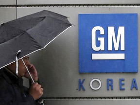 FILE - In this April 23, 2018, file photo, a worker of General Motors Korea talks on the mobile phone outside the factory in Bupyeong, South Korea.