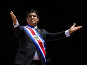 Costa Rica's President Carlos Alvarado greets the public wearing the presidential sash during his swearing-in ceremony, in San Jose, Costa Rica, Tuesday, May 8, 2018. Alvarado won last month's presidential runoff as many voters rejected an evangelical pastor who had jumped into political prominence by campaigning against same-sex marriage. (Costa Rica Foreign Ministry via AP)