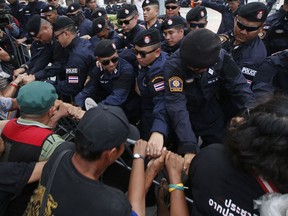 Thai pro-democracy protesters confront with riot police during a gathering marking the fourth anniversary of the military take-over of government in Bangkok, Thailand, Tuesday, May 22, 2018. Police in the Thai capital blocked a march Tuesday by pro-democracy activists protesting four years of military rule and calling for elections this year.