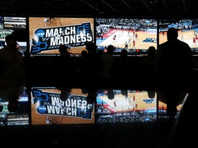 In this March 15, 2018 photo, people watch coverage of the first round of the NCAA college basketball tournament at the Westgate Superbook sports book in Las Vegas.