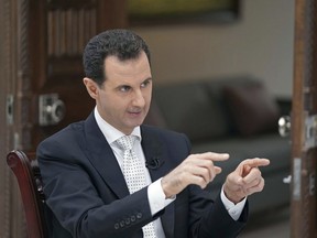 In this photo released Thursday, May 10, 2018, by the Syrian official news agency SANA, Syrian President Bashar Assad speaks during an interview with the Greek Kathimerini newspaper, in Damascus, Syria.