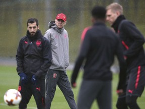 Arsenal manager Arsene Wenger, second left, watches his players during a training session at London Colney, England, Wednesday May 2, 2018 ahead of their Europa League semifinal second leg match against Atletico Madrid.