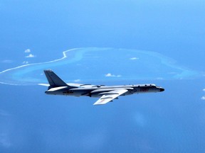 FILE - In this undated file photo released by Xinhua News Agency, a Chinese H-6K bomber patrols the islands and reefs in the South China Sea. The China Daily newspaper reported Saturday, May 19, 2018 that People's Liberation Army Air Force conducted takeoff and landing training with the H-6K bomber in the South China Sea.