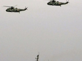 FILE - This Sept. 29, 2005, file photo shows U.S. navy warship USS Higgins and two Indian navy Sea King helicopters during the India-US joint naval exercise in the Arabian Sea, India.  A statement on the Defense Ministry's website said the Arleigh Burke class guided-missile destroyer USS Higgins and Ticonderoga class guided-missile cruiser USS Antietam entered waters China claims in the Paracel island group "without the permission of the Chinese government."