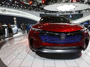 FILE - In this April 26, 2018, file photo, visitors look at a Buick Enspire concept car on display at the China Auto China in Beijing. China has announced it will reduce auto import duties effective July 1 following promises to buy more U.S. goods and end restrictions on foreign ownership in the industry. The Finance Ministry said Tuesday, May 22, 2018,  that charges for many imported vehicles will be reduced from 25 percent to 15 percent.