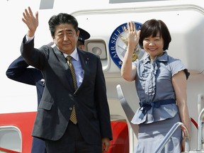 Japan's Prime Minister Shinzo Abe, left, and his wife Akie wave as they depart for Russia at Haneda Airport in Tokyo, Thursday, May 24, 2018. Abe headed to Russia on Thursday for talks with President Vladimir Putin, in hopes of making progress on joint economic projects on disputed islands as a step toward resolving the decades-old territorial row. (Kyodo News via AP)