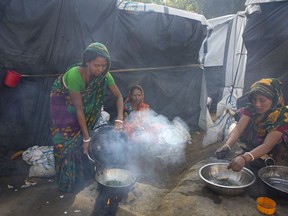 FILE - In this Jan. 19, 2018, file photo,  Hindu women refugees prepare supper at their camp near Cox's Bazar, Bangladesh. Amnesty International said Wednesday, May 23, 2018,  that Myanmar's army was not the only force that has slaughtered civilians in the country's volatile west.  In a new report, the rights group accused ethnic Rohingya insurgents of carrying out at least one brutal massacre of minority Hindus when the long-running conflict in Rakhine state exploded last year.