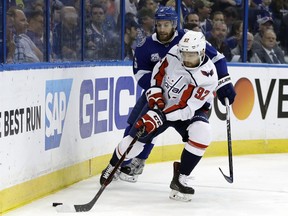 Washington Capitals center Evgeny Kuznetsov, front, moves the puck away from Tampa Bay Lightning defenseman Dan Girardi during the first period of Game 7 of the NHL hockey Eastern Conference finals Wednesday, May 23, 2018, in Tampa, Fla.