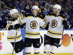 Boston Bruins defenseman Torey Krug (47) celebrates his goal against the Tampa Bay Lightning with left wing Brad Marchand (63) and right wing David Pastrnak (88) during the third period of Game 2 of an NHL second-round hockey playoff series Monday, April 30, 2018, in Tampa, Fla.