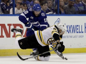 Boston Bruins left wing Brad Marchand, lower right, falls after getting tangle up with Tampa Bay Lightning center J.T. Miller (10) during the first period of Game 2 of an NHL second-round hockey playoff series Monday, April 30, 2018, in Tampa, Fla.