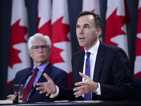 Finance Minister Bill Morneau and Natural Resources Minister James Carr speak at the National Press Theatre during a press conference in Ottawa on Tuesday, May 29, 2018.