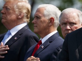 Attorney General Jeff Sessions stands for the national anthem during the 37th annual National Peace Officers Memorial Service on Capitol Hill, Tuesday, May 15, 2018, in Washington. From left, President Donald Trump, Vice President Mike Pence, and Sessions.