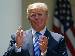 U.S. President Donald Trump applauds during a presentation about prescription drug prices by Health and Human Services Secretary Alex Azar, in the White House Rose Garden on May 11, 2018.