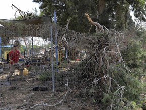 A man clear trees damaged by mortar shells fired from the Gaza Strip in a kindergarten at a kibbutz near the Israel Gaza border, Tuesday, May 29, 2018. Gaza militants fired more than 25 mortar shells toward communities in southern Israel Tuesday, the Israeli military said, in what appeared to be the largest single barrage fired since the 2014 Israel-Hamas war.