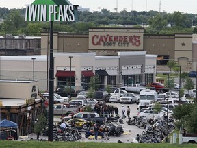 FILE - In this May 17, 2015 file photo, authorities investigate a shooting in the parking lot of Twin Peaks restaurant in Waco, Texas. Prosecutors have dismissed another 42 cases relating to the 2015 shooting in Waco involving rival biker gangs that left nine dead and 20 others injured. McLennan County prosecutors said Tuesday, May 8, 2018, they're dismissing the cases while focusing on "more culpable" defendants.