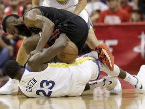 Houston Rockets guard James Harden, top, battles Golden State Warriors forward Draymond Green for a loose ball during the first half in Game 5 of the NBA basketball playoffsWestern Conference finals in Houston, Thursday, May 24, 2018.