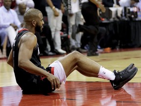 Houston Rockets guard Chris Paul sits on the floor after being hurt during the second half in Game 5 against the Golden State Warriors in the NBA basketball playoffs Western Conference finals in Houston, Thursday, May 24, 2018.