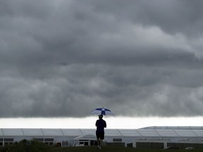 A lone fan stands along the course using an umbrella to shield himself from the rain during the rain-suspended final round of the AT&T Byron Nelson golf tournament, Sunday, May 20, 2018, in Dallas, Texas.