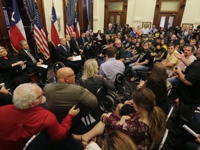 Scot Rice, standing right, speaks during a roundtable discussion in Austin, Texas, Thursday, May 24, 2018, hosted by Texas Gov. Gregg Abbott to address safety and security at Texas schools in the wake of the shooting at Santa Fe, Texas. Rice's wife Flo Rice, a substitute teacher, was carried from the Santa Fe scene of last week's school shooting after she was shot in the leg.