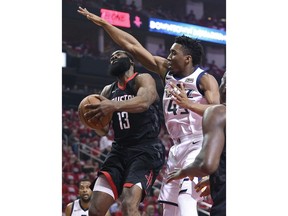 Houston Rockets guard James Harden (13) drives to the basket as Utah Jazz guard Donovan Mitchell, right, defends during the first half in Game 2 of an NBA basketball second-round playoff series Wednesday, May 2, 2018, in Houston.