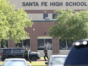FILE - In this May 18, 2018, file photo, law enforcement officers respond to Santa Fe High School after an active shooter was reported on campus in Santa Fe, Texas. Texas holds its primary runoff election Tuesday, May 22, 2018, just four days after a trench coat-clad student killed at least 10 people and wounded others at Santa Fe High School near Houston. But it's unlikely to be a major factor in Tuesday's balloting, which will decide 34 races, including for governor and Congress, where no candidate won at least 50 percent of the votes cast during Texas' March 6 primary.