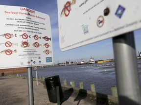 In this March 1, 2018 photo, signs warn people not to fish or crab at River Terrace Park in Channelview, Texas, one of four county parks adjacent to hotspots in the San Jacinto River Waste Pits.