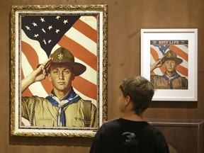 FILE - In this July 22, 2013, file photo, Andrew Garrison, 11, of Salt Lake City, looks over the Rockwell exhibition at the Mormon Church History Museum in Salt Lake City, Utah. Twenty-three original, Boy Scout-themed Norman Rockwell paintings were on display in Salt Lake City to celebrate the 100-year relationship between Scouting and the Mormon church. An announcement Tuesday night, May 8, 2018, by The Church of Jesus Christ of Latter-day Saints and Boy Scouts will mark an end to close relationship that lasted more than a century built on their shared values. The religion will move its remaining boys into its own scouting-type program.