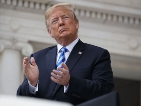 President Donald Trump applauds during a Memorial Day ceremony at Arlington National Cemetery, Monday, May 28, 2018, in Arlington, Va.