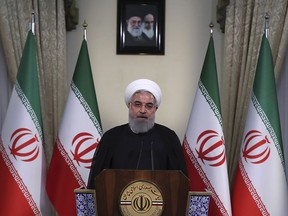 In this photo released by official website of the office of the Iranian Presidency, President Hassan Rouhani addresses the nation in a televised speech in Tehran, Iran, Tuesday, May 8, 2018. Iranian President Hassan Rouhani said Tuesday he'd send his foreign minister to negotiate with countries remaining in the nuclear deal after Donald Trump's decision to pull America from the deal, warning he otherwise would restart enriching uranium "in the next weeks." (Iranian Presidency Office via AP)