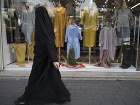 An Iranian woman looks at a shop in Tehran, Iran, Monday, May 7, 2018. Iranian President Hassan Rouhani has seen his influence wane as his signature achievement, the nuclear deal with world powers, is now under threat from President Donald Trump. Economic problems, as well as some suggesting a military dictatorship for the country, suggest Iran's domestic politics may swing back toward hard-liners and further weaken the once-popular president.