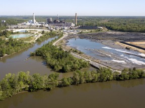 The Richmond city skyline can be seen on the horizon behind the coal ash ponds along the James River near Dominion Energy's Chesterfield Power Station in Chester, Va., Tuesday, May 1, 2018. Virginia's governor says the state has no plans to change its coal ash management practices, despite an Environmental Protection Agency proposal that would roll back federal regulations governing the byproduct generated by coal-burning power plants.