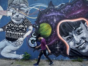 A man walks by a mural of Daiana Garnic, a 17-year-old girl who has been missing since last year, in Buenos Aires, Argentina, Tuesday, May 15, 2018. Garnica is one of five images of missing youngsters painted in walls across Buenos Aires to raise awareness about their disappearance.