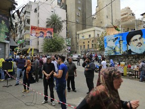 Posters showing Hezbollah leader Hassan Nasrallah hang outside a polling station during Lebanon's parliamentary elections, in Beirut, Lebanon, Sunday, May 6, 2018. Tens of thousands of Lebanese began casting their ballots Sunday in the first parliamentary elections in nine years, with people lining up early in the morning to take part in a vote that is being fiercely contested between rival groups backed by regional powers.