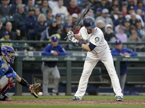 Texas Rangers catcher Robinson Chirinos, left, reaches for but misses a wild pitch as Seattle Mariners' Gordon Beckham looks on in the fourth inning of a baseball game Wednesday, May 30, 2018, in Seattle. Mike Zunino scored.