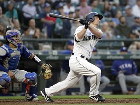 Seattle Mariners' Kyle Seager watches his three-run double in front of Texas Rangers catcher Robinson Chirinos during the third inning of a baseball game Tuesday, May 15, 2018, in Seattle.