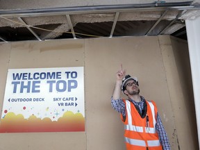 In this photo taken April 18, 2018, Space Needle facilities and construction superintendent Matt Waffle points out work being done on the ceiling overhead on the viewing level of the landmark structure in Seattle. The family-owned building is set to unveil the biggest renovation in its 56 year history next month, a $100 million investment in a single year of construction that transformed the structure's top viewing level some 500-feet above ground. The preservation and renovation project included the installation of floor-to-ceiling glass on the viewing deck, updated the structure's physical systems and adds a glass floor to the rotating restaurant.
