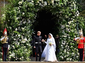 The royally wedded couple emerge from the doors of Windsor chapel, and stand at the top of the stairs as an officially married royal couple.