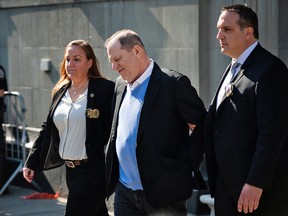 Harvey Weinstein is escorted in handcuffs out of the New York Police Department 1st Precinct in New York, U.S., on Friday, May 25, 2018.