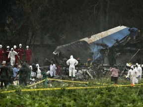 In this Friday, May 18, 2018 photo, rescue teams search through the wreckage site of a Boeing 737 that plummeted into a farm field with more than 100 passengers on board, in Havana, Cuba. The Cuban airliner crashed just after takeoff from Havana's international airport in Havana, Cuba.