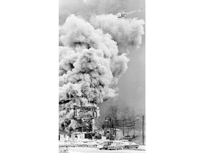 FILE - In this Nov. 20, 1968, file photo, a helicopter hovers over the burning Llewellyn portal to the Mountaineer Coal Co. No. 9 mine near Farmington, W.Va. It's been nearly half a century since 78 men perished in the Farmington No. 9 mine disaster in West Virginia, but to those who lost loved ones, the questions have never been answered. This week, families of the lost miners will ask a federal appeals court to reinstate a lawsuit they filed in 2014.  (Charleston Gazette-Mail via AP, File)