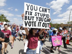 FILE - In this March 24, 2018 file photo, people take part in a "March For Our Lives" rally Saturday, March 24, 2018, in Parkland, Fla. TA new poll from The Associated Press-NORC Center for Public Affairs Research and MTV reveals a significant surge in the number of young people who feel politically empowered, a change that comes after a school shooting in Florida elevated the voices of high school students in American politics.