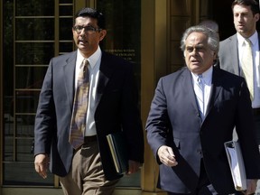 FILE - In this May 20, 2014 file photo, conservative scholar and filmmaker Dinesh D'Souza, left, accompanied by his lawyer Benjamin Brafman leaves federal court, in New York. President Donald Trump says he will pardon conservative commentator Dinesh D'Souza who pleaded guilty to campaign finance fraud. Trump tweeted Thursday: "Will be giving a Full Pardon to Dinesh D'Souza today. He was treated very unfairly by our government!" D'Souza was sentenced in 2014 to five years' probation after he pleaded guilty to violating federal election law.