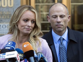 FILE - In this April 16, 2018, file photo, adult film actress Stormy Daniels, left, stands with her lawyer Michael Avenatti as she speaks outside federal court in New York. The story told by President Donald Trump and the White House about payments made to Daniels has evolved over time. The White House has consistently denied Trump had an affair with Daniels, but statements from the president and his aides about a hush money payment made just before the 2016 election have changed.