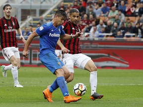 Fiorentina's Giovanni Simeone, left, scores his side's opening goal as AC Milan's Ricardo Rodriguez tries to stop him during the Serie A soccer match between AC Milan and Fiorentina at the San Siro stadium in Milan, Italy, Sunday, May 20, 2018.