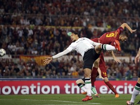 Liverpool's Virgil Van Dijk jumps for the ball with Roma's Edin Dzeko, right, during the Champions League semifinal second leg soccer match between Roma and Liverpool at the Olympic Stadium in Rome, Wednesday, May 2, 2018.