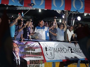 Malaysia's reformist icon Anwar Ibrahim, center, gestures to his supporters during a rally in Petaling Jaya, Malaysia, Wednesday, May 16, 2018.  Reformist icon Anwar Ibrahim celebrated a "new dawn" for Malaysia after he was given a royal pardon and freed from custody Wednesday, transforming a political prisoner into a prime minister-in-waiting following his alliance's stunning election victory.
